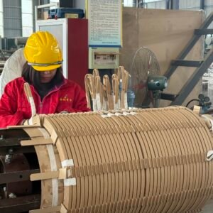 Skilled worker winding a transformer coil in the production workshop