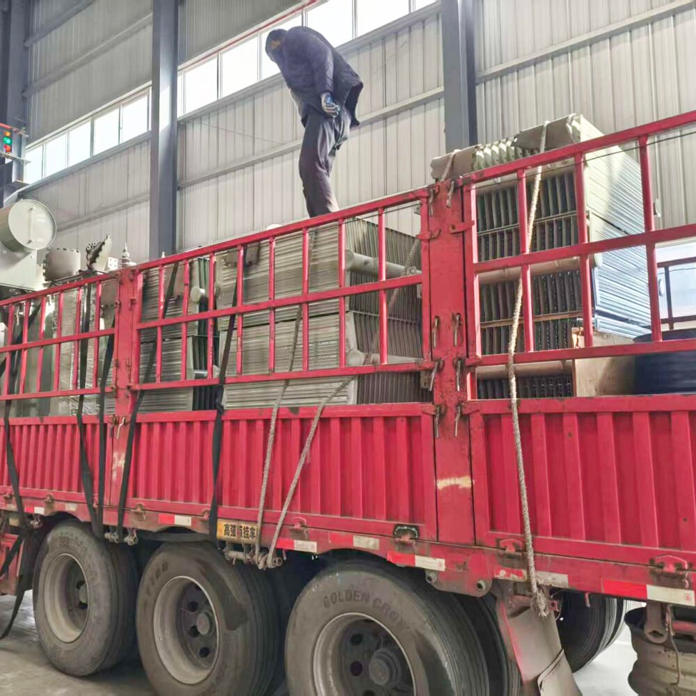 Worker securing transformers on a truck before transport