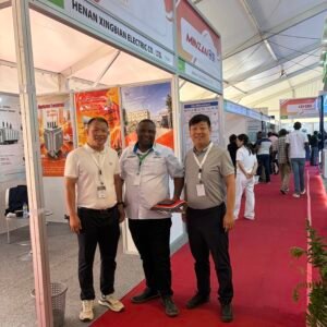 XNET team with an international visitor at the Henan Xingbian Electric exhibition booth
